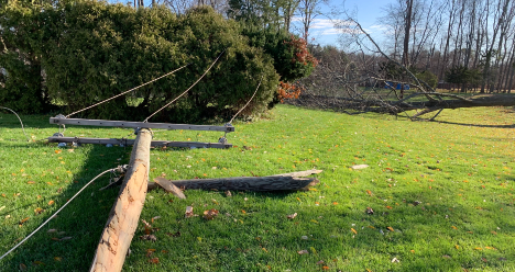 Pole and wires down in a yard after a storm