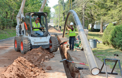 Eversource employees work to install new gas pipes in the street.