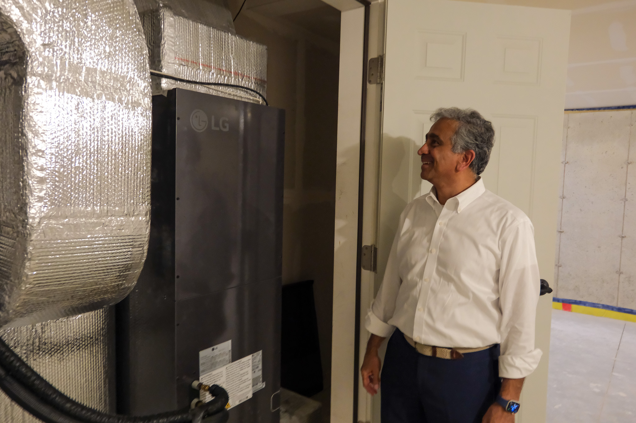 Eversource Vice President of Energy Efficiency and Electric Mobility Tilak Subrahmanian tours one of the net zero homes at the Barrett Hill subdivision in Hudson.