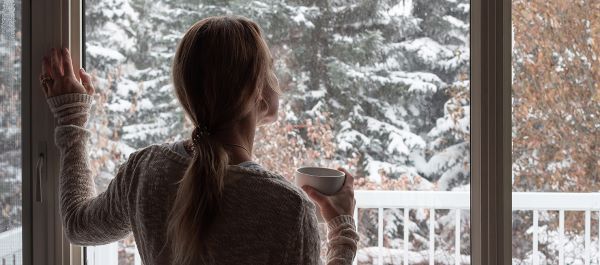 woman-looking-out-window-winter