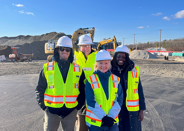 Diverse employees pose in the field