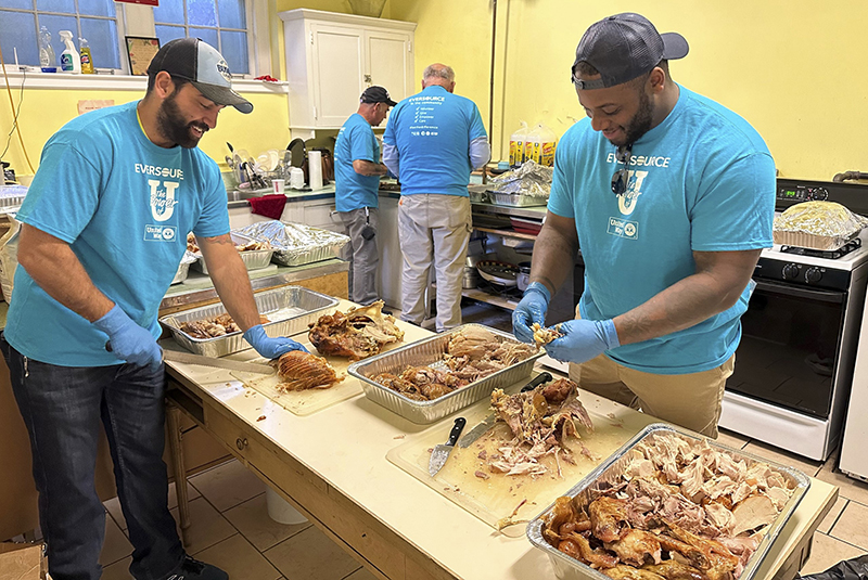 Volunteers in an industrial kitchen preparing food for a Thanksgiving meal