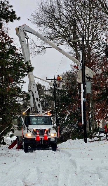 An Eversource crew conducts repair work on a snow-buried road in Falmouth.