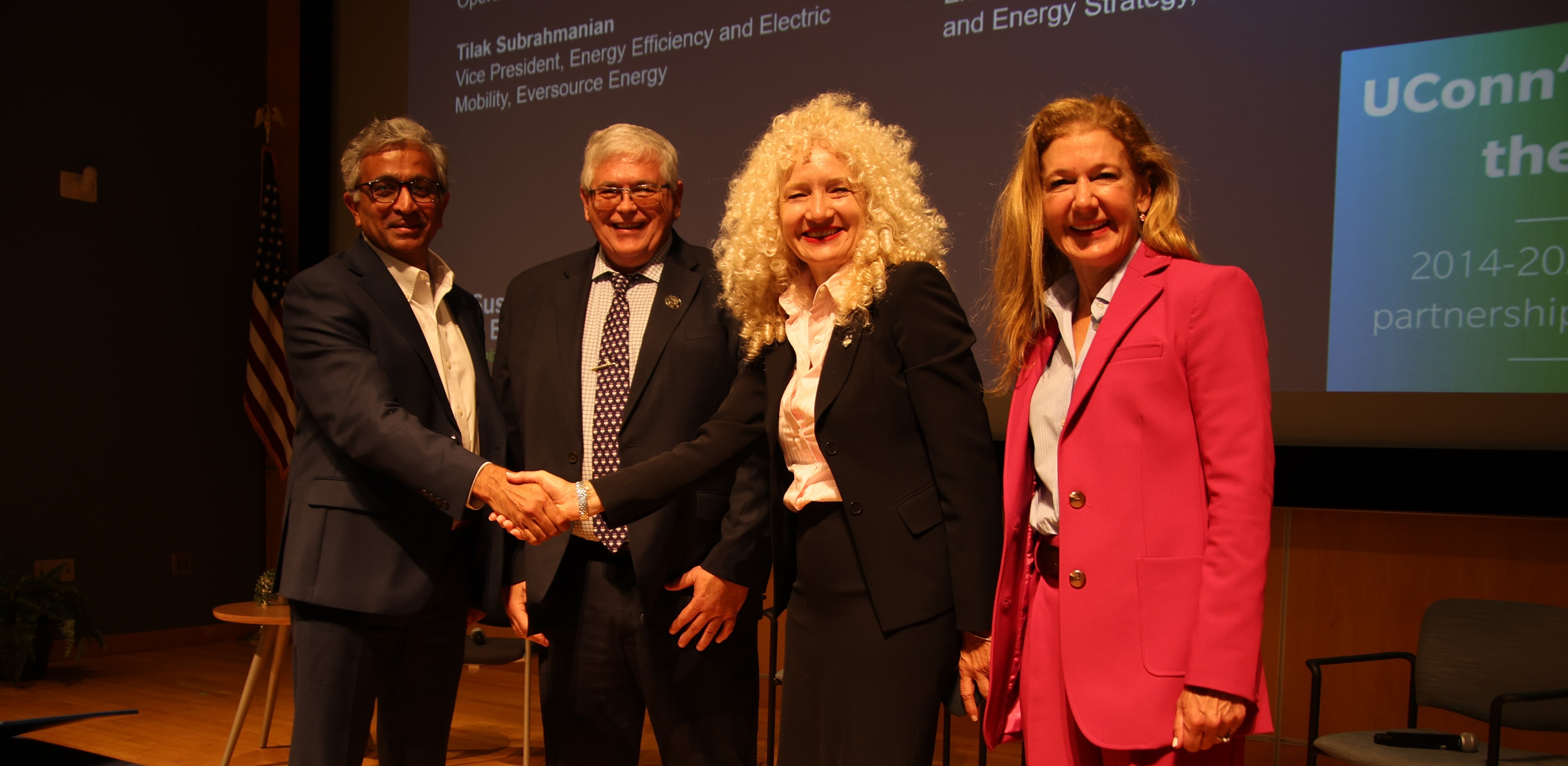 Tilak Subrahmanian, Vice President shakes hands with UConn President Radenka Maric alongside Stan Nolan, Associate Vice President and Eversource Executive Vice President Penni McLean-Conner after the signing of a new strategic energy efficiency agreement.